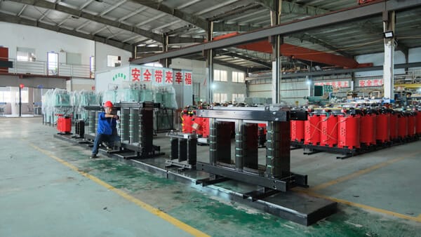 Baitong Electric factory floor: Professional workers assembling high-efficiency cast resin dry type transformers in a clean, large-scale manufacturing facility.