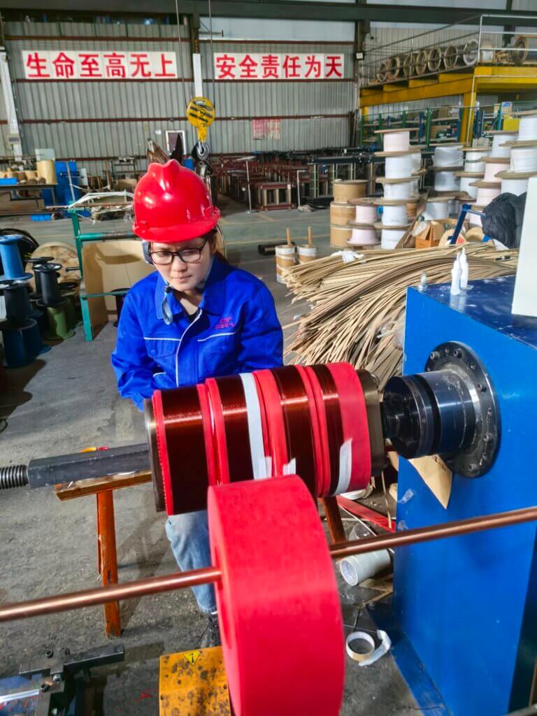 Skilled worker operating a winding machine to create high-quality copper coils for S11 oil-immersed transformers at Baitong Electric factory.