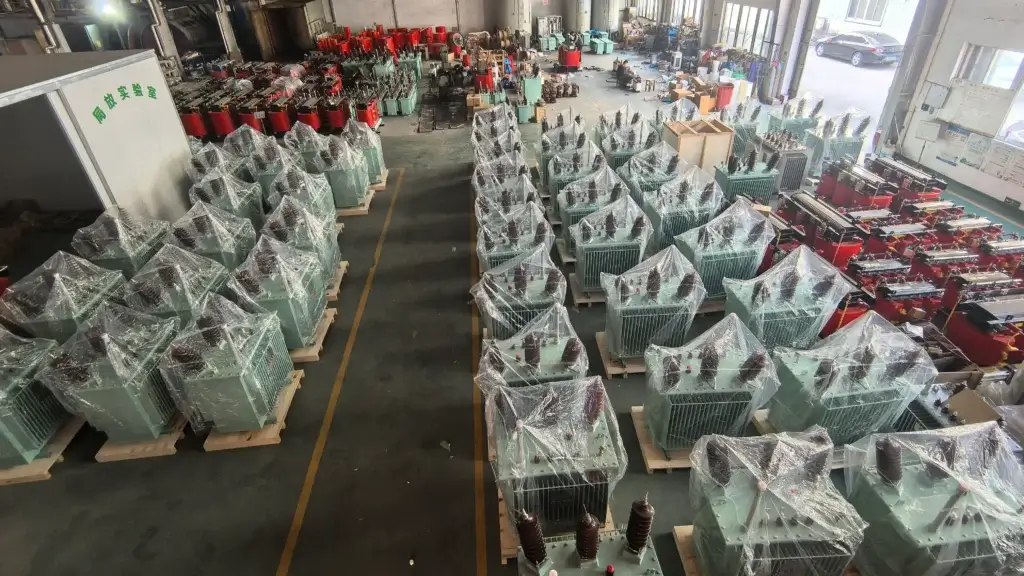 Rows of newly manufactured S11 series oil immersed transformers wrapped and packed on wooden pallets, ready for shipment in Baitong Electric's modern factory workshop