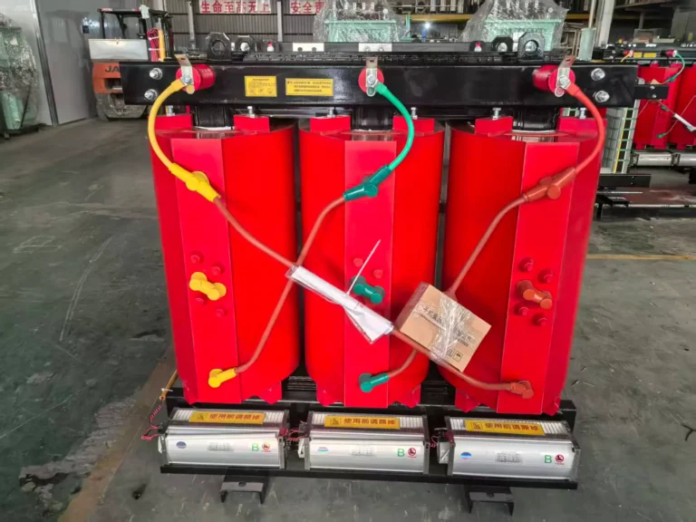 Red epoxy cast resin coils and cooling fans of a dry type transformer on the factory floor, built by outdoor dry type transformer manufacturer Baitong Electric, ready for enclosure integration.