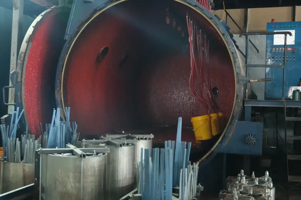 A close-up view inside a massive vacuum casting chamber showing resin delivery hoses and prepared coil molds for the dry type transformer manufacturing process at the Baitong Electric factory.