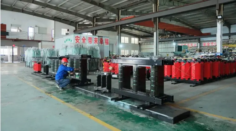 A Baitong Electric technician assembling a magnetic core next to red cast resin coils, demonstrating why we use dry type transformer technology for maximum safety.