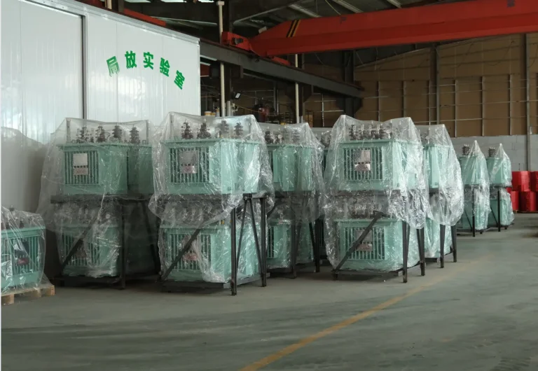 Dozens of premium oil-immersed transformer units wrapped in plastic and stacked on steel racks outside the testing laboratory at the Baitong Electric factory.