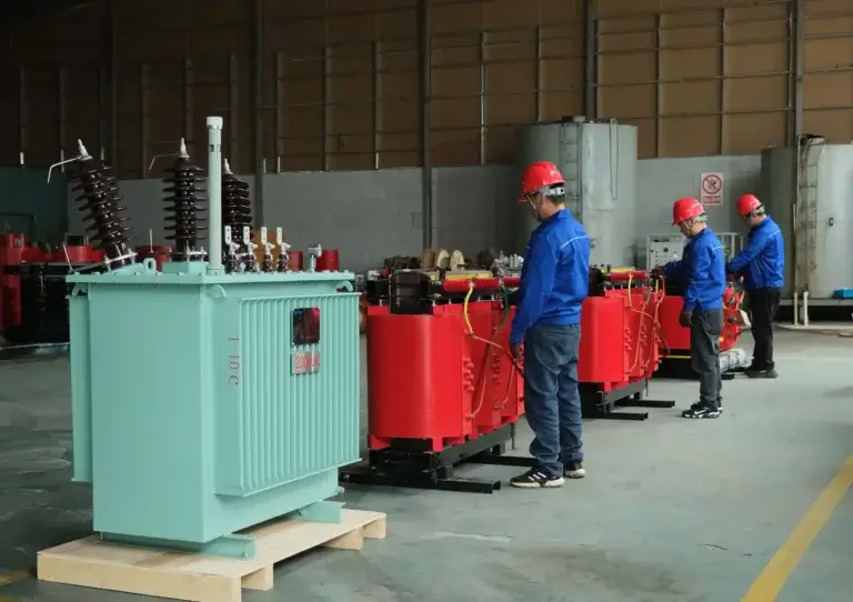 A side-by-side view on the Baitong Electric factory floor comparing a green oil immersed transformer and workers assembling red dry type transformers.