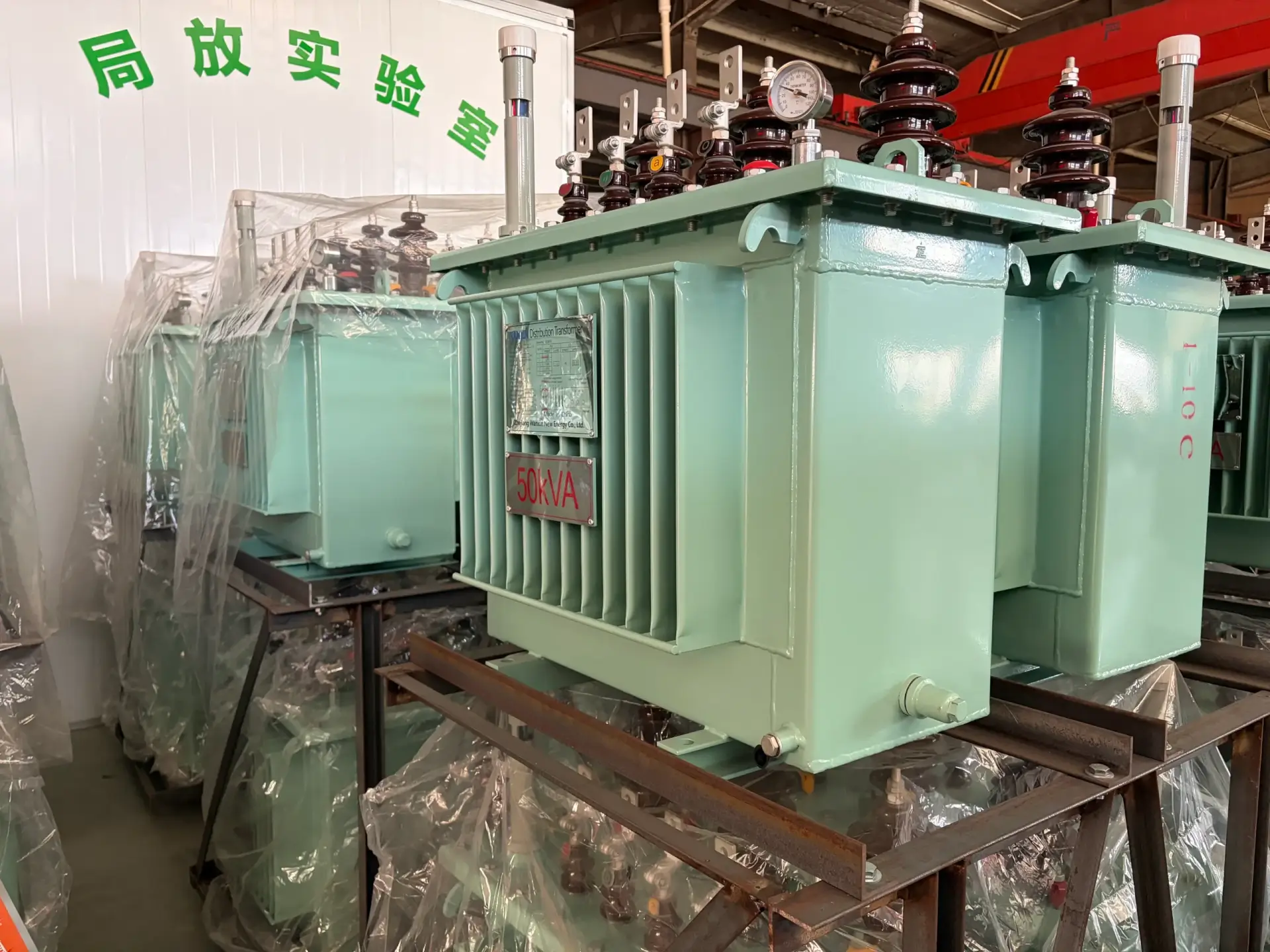 A brand new green s13-20kv 50kva oil immersed transformer waiting outside the partial discharge testing laboratory at the Baitong Electric factory.