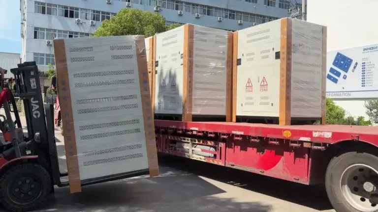 A heavy forklift loading fully enclosed power equipment onto a truck for transformer bulk delivery at the Baitong Electric factory.
