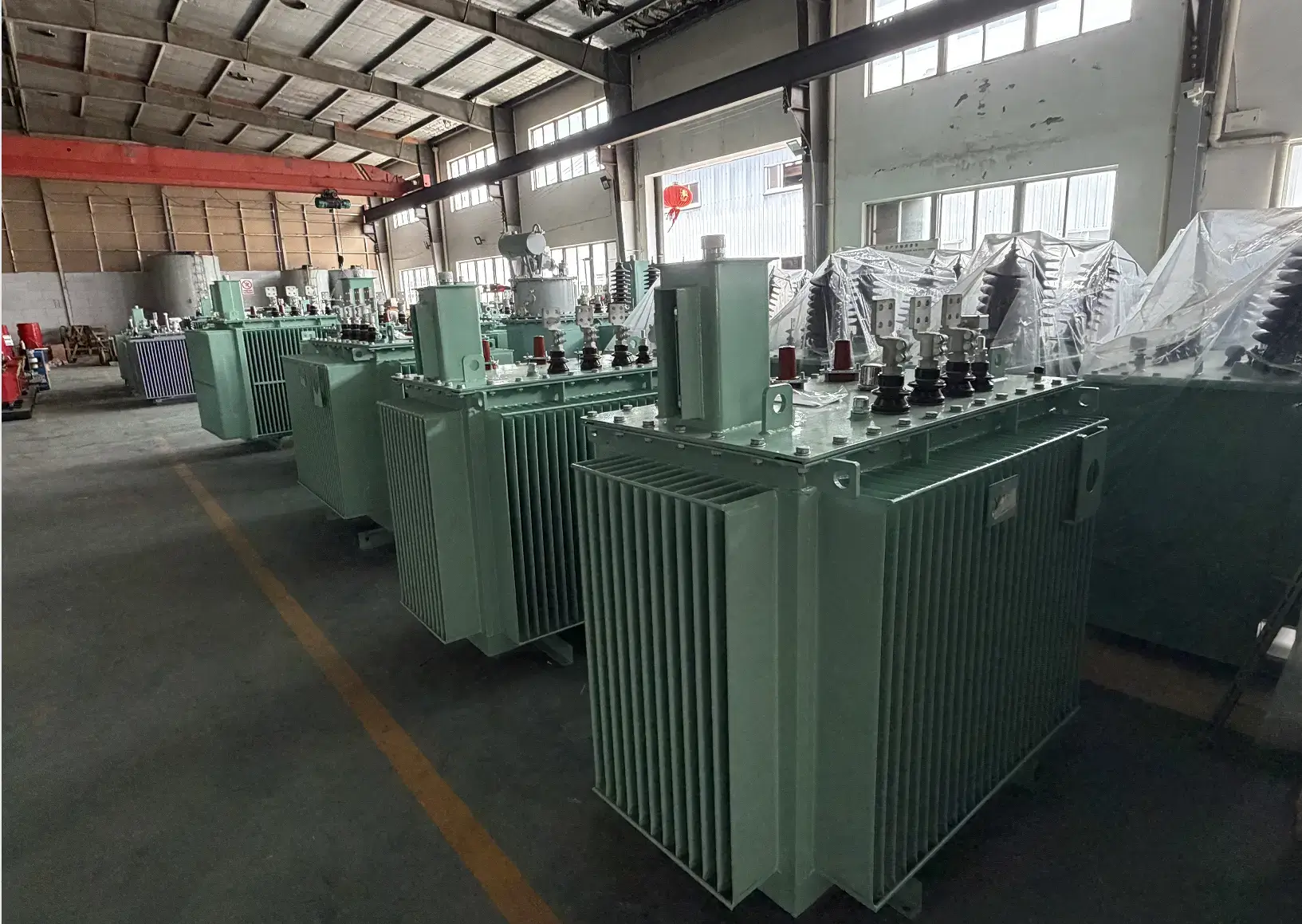A large batch of green 300kva transformer oil filled units lined up on the Baitong Electric factory floor, ready for strict testing and global export.