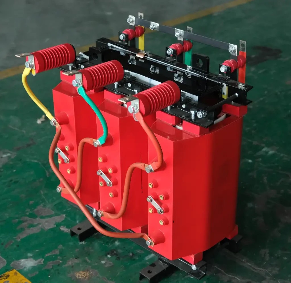 A close-up view of essential parts of dry type transformer, featuring red cast resin coils and high-voltage insulators on the Baitong Electric factory floor.