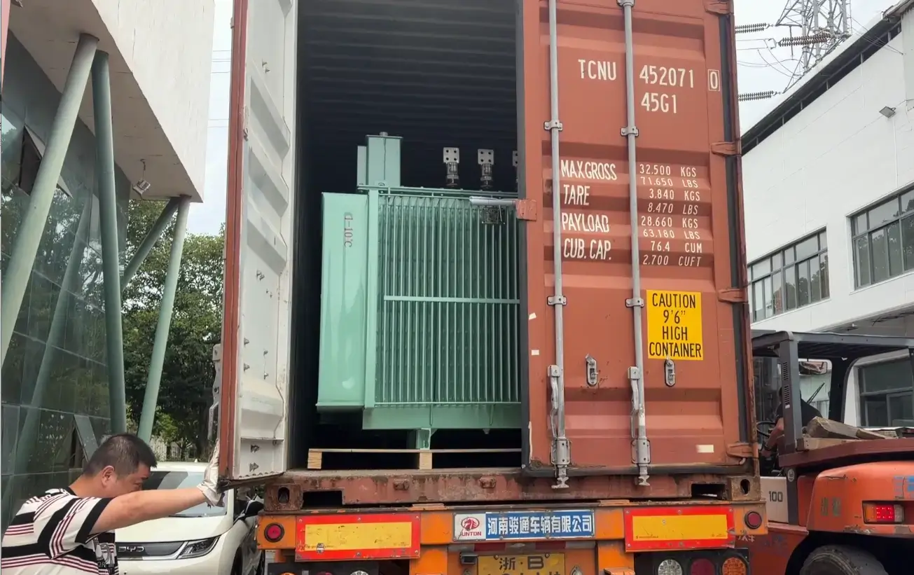 Baitong Electric factory workers using a forklift to load a green oil-immersed unit into a high cube transformer shipping container.