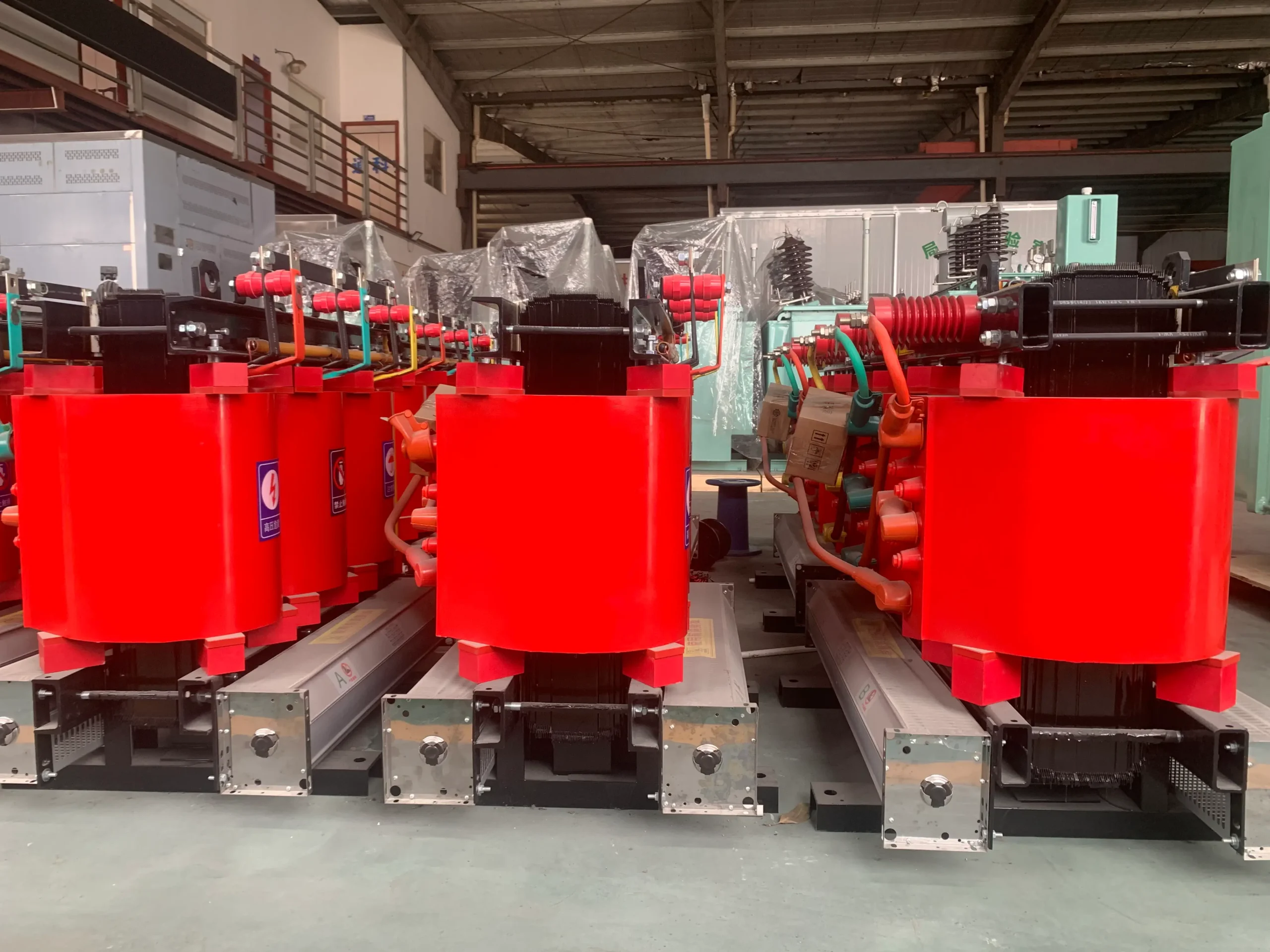 Medium dry type transformers with red resin-insulated windings and cooling fans in the BTCN Electric factory